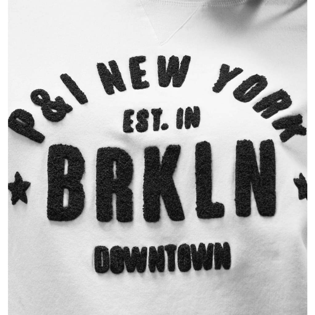 Penn & Ink Sweater. Weiß mit gesticktem Logo in schwarz. Langarm Logo-Pullover.
