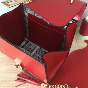 Kleine Ledertasche rot mit Henkel. Elegante Handtasche mit Innenfutter mit Zeitungsmotiv und Innenfach aus Leder. Perfekte Tasche zum Ausgehen.
