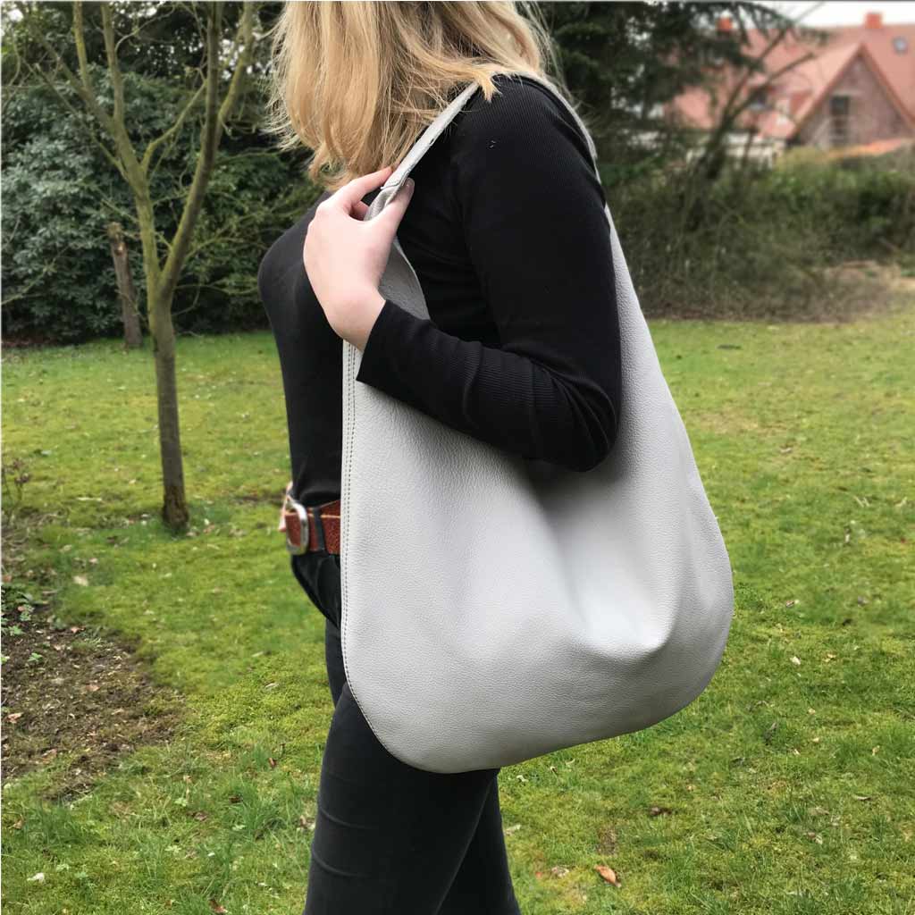 Graue Ledertasche mit Henkel. hellgraue Hobo Bag. Große minimalistische Ledertasche für Damen handgefertigt. Taschen Trend in klassischen Farben.
